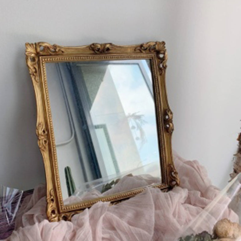 Square vintage-style gold mirror with ornate baroque frame. A luxurious decorative accent for classic and elegant home decor.